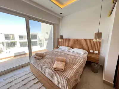 a bedroom with a large bed and a large window at Maraya El Gouna in Hurghada