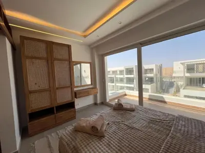 a bedroom with a bed and a large window at Maraya El Gouna in Hurghada