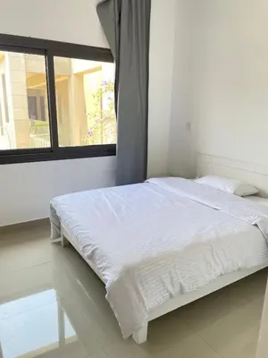 a white bed in a room with a window at Two-bedroom apartment in G Cribs in Hurghada