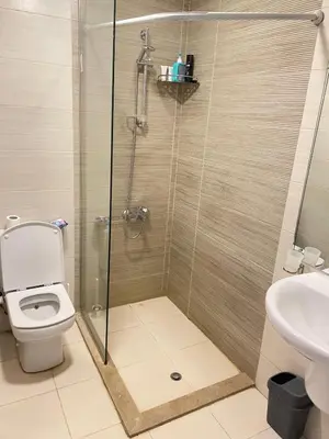 a bathroom with a shower with a toilet and a sink at Two-bedroom apartment in G Cribs in Hurghada