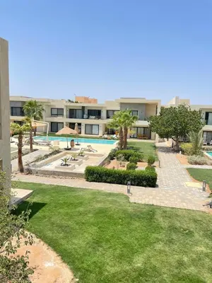 a view of a building with a pool and a yard at Two-bedroom apartment in G Cribs in Hurghada