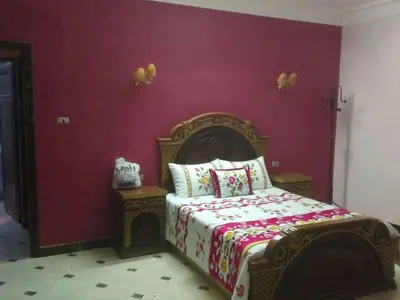 a bedroom with a bed and a purple wall at Tetas Villa in Naj‘ al Maḩaţţah