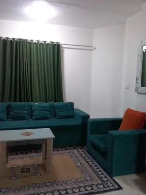 a living room with a green couch and a table at Rich Home Hurghada in Hurghada