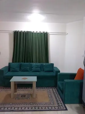 a living room with a blue couch and a table at Rich Home Hurghada in Hurghada