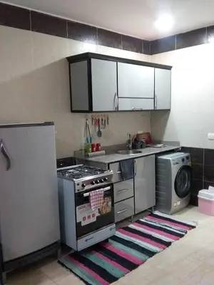 a kitchen with a stove and a washing machine at Rich Home Hurghada in Hurghada