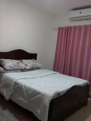 a bed in a bedroom with a pink curtain at Rich Home Hurghada in Hurghada