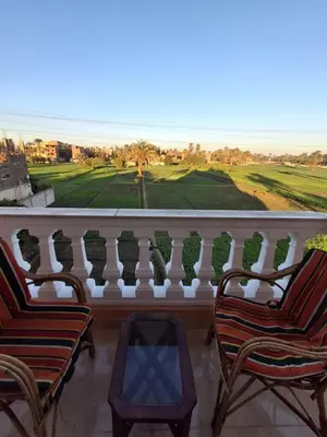 a balcony with chairs and a view of a golf course at El Agamy Hotel Apartment in Luxor
