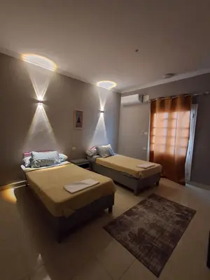 a bedroom with two beds and a rug at El Agamy Hotel Apartment in Luxor