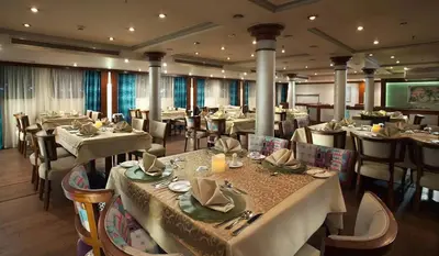 a dining room with tables and chairs in a restaurant at سحس جروب in Luxor