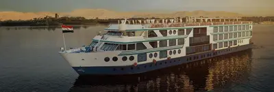 a cruise ship in the water with a flag at سحس جروب in Luxor