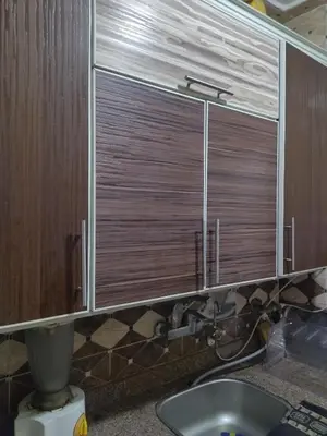 a bathroom with a sink and a window with wooden cabinets at شقة صغيرة قريبة من شاطئ البحر في سفاجا in Safaga