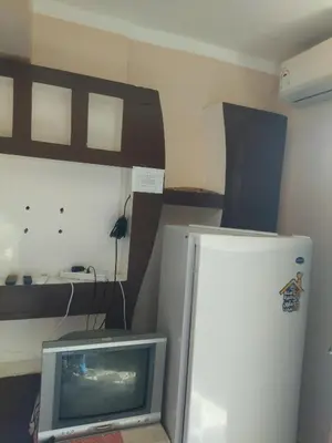 a living room with a tv and a bed at شقة صغيرة قريبة من شاطئ البحر في سفاجا in Safaga