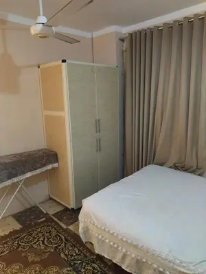 a bedroom with a bed and a cabinet and a window at شقة صغيرة قريبة من شاطئ البحر في سفاجا in Safaga