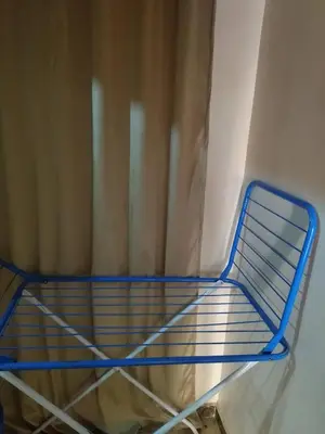 a blue shelf in a room with a curtain at شقة صغيرة قريبة من شاطئ البحر في سفاجا in Safaga