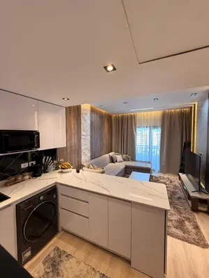 a kitchen and living room with a couch and a stove at Luxury Sea View Apartment Near Hurghada Airport in Hurghada