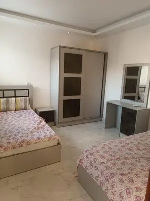 a bedroom with two beds and a desk in it at ميراج باى in Hurghada