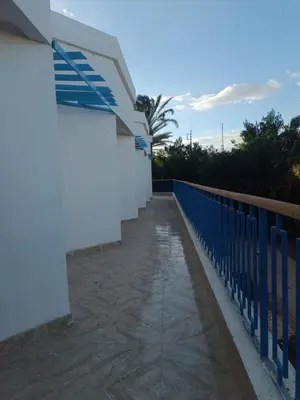 a walkway next to a white building with a blue fence at ميراج باى in Hurghada