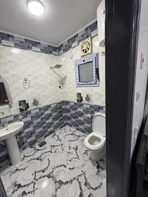 a bathroom with a toilet and a sink and a tv at fayrouz in Al Aqālitah