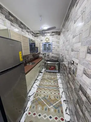 a kitchen with a counter and a tile wall at fayrouz in Al Aqālitah