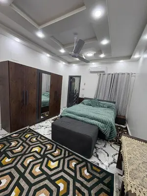 a bedroom with two beds and a rug at fayrouz in Al Aqālitah