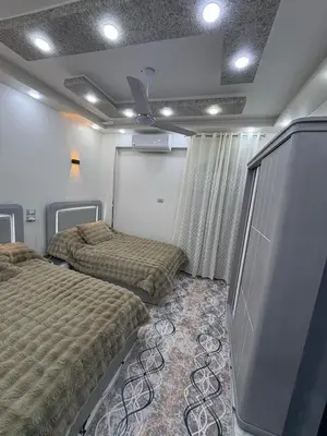 a bedroom with two beds and a tv in it at fayrouz in Al Aqālitah