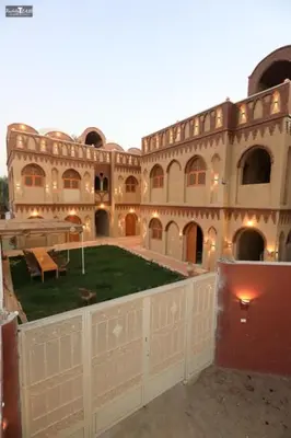 a large building with a yard in front of it at Nefertari Palace apartments in Al Aqālitah