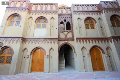 a large building with brown doors and windows at Nefertari Palace apartments in Al Aqālitah