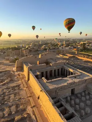 a group of hot air balloons flying over the city at NOOR SEEN House in Luxor