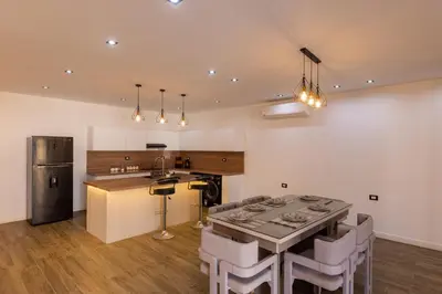 a kitchen with a table and some chairs in a room at Private Villa AL Mamsha Private Pool in Hurghada