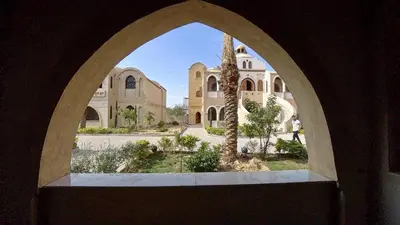 an arched window in a building with a palm tree at Saray el omda wellness &retreat village in Al Karnak