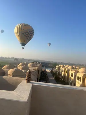 a hot air balloon flying over a building at Saray el omda wellness &retreat village in Al Karnak