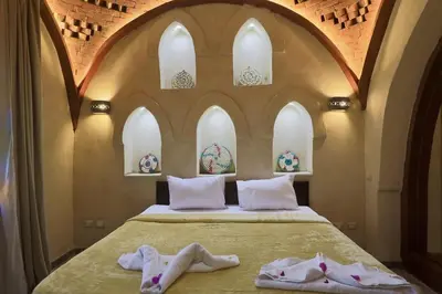 a bedroom with a bed with two pairs of slippers at Saray el omda wellness &retreat village in Al Karnak