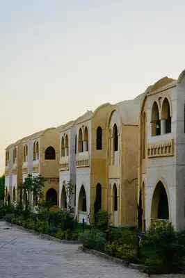 a large building with arched windows and a courtyard at Saray el omda wellness &retreat village in Al Karnak