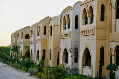 a large building with arches and windows on it at Saray el omda wellness &retreat village in Al Karnak
