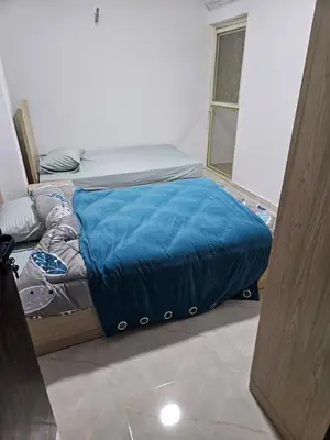 a bedroom with a bed with a blue blanket at Sky View in Hurghada