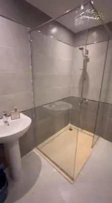 a bathroom with a glass shower and a sink at Humbra in Hurghada