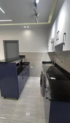 a kitchen with black counter tops and a tile floor at Humbra in Hurghada