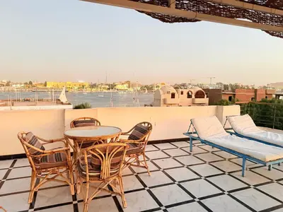 a patio with a table and chairs on a roof at Qasr El Nil in Luxor