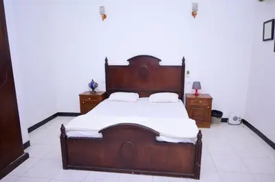 a bedroom with a large wooden bed with white sheets at Qasr El Nil in Luxor