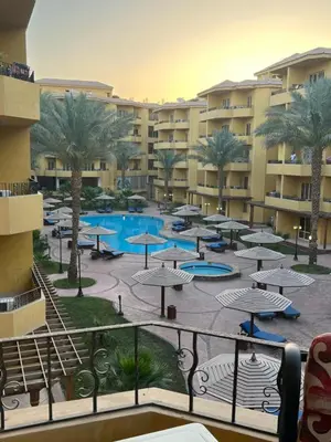 a view of a resort with a pool and umbrellas at Modern Apartment in the Britsh Resort in Hurghada