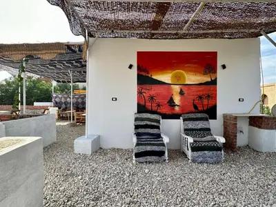 a room with two chairs and a painting on the wall at In Luxor in Luxor