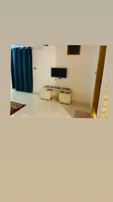 a room with two beds and a flat screen tv at In Luxor in Luxor
