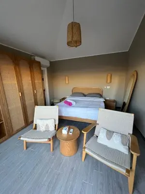 a bedroom with a bed and two chairs and a table at Bali elgouna private heated pool in Hurghada