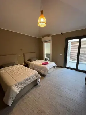 a bedroom with two beds and a light fixture at Bali elgouna private heated pool in Hurghada