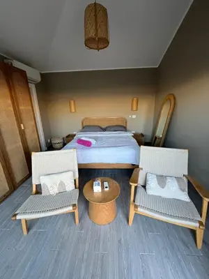 a bedroom with a bed and two chairs and a table at Bali elgouna private heated pool in Hurghada