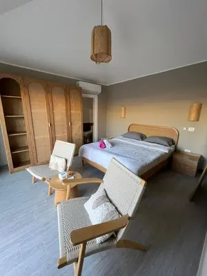 a bedroom with a bed and two chairs at Bali elgouna private heated pool in Hurghada