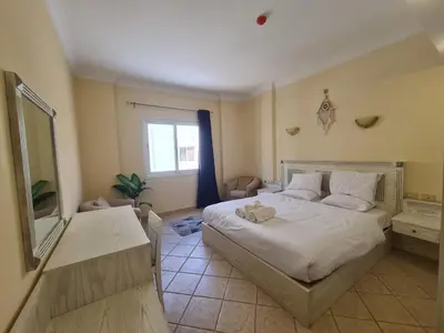 a bedroom with a large bed and a mirror at Stunning One-Bedroom Apartment at the prestigious Palm Beach Piazza in Hurghada