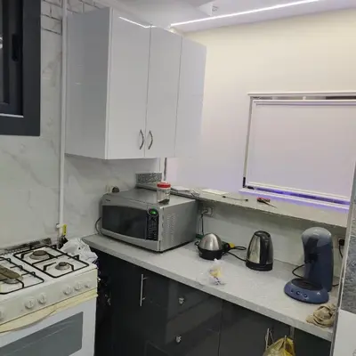a small kitchen with a microwave and a stove at Appartement 2 slaapkamers in Hurghada