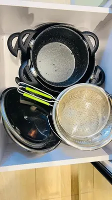 a group of pans and utensils sitting on a shelf at Luxury apartment pool view in Hurghada