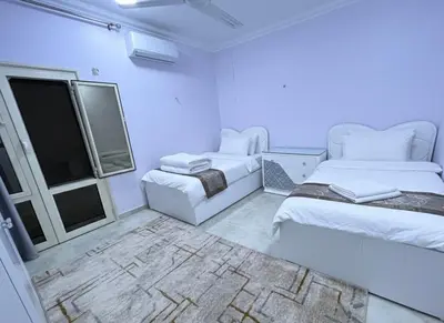 a white room with two beds and a window at Hobby live in Hurghada in Hurghada